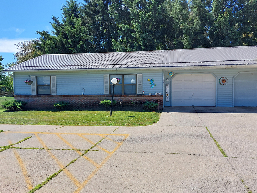 a white house with two garage doors and a driveway